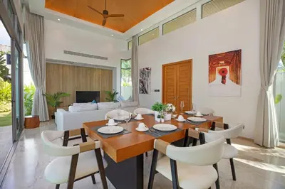 a dining room with a table and chairs and a couch at Luxury Villa in heart of Bang Tao! Villa BEAM in Laguna Phuket