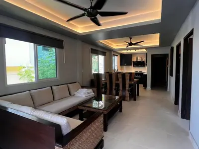 a living room with a couch and a table at Newly Renovated Sea View House in Karon Beach