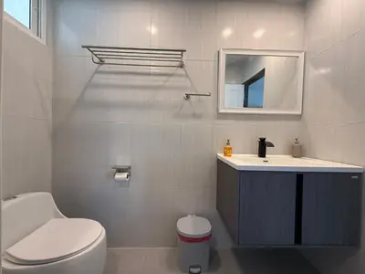 a bathroom with a toilet and a sink and a mirror at Newly Renovated Sea View House in Karon Beach