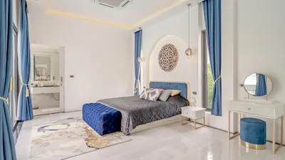 a bedroom with a bed with blue curtains and a mirror at Bang Tao Luxury Villa - Menara Hill in Ban Phak Chit