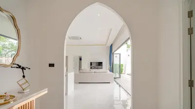 an arched doorway leads to a living room with a fireplace at Bang Tao Luxury Villa - Menara Hill in Ban Phak Chit