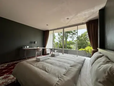 a large bed in a room with a large window at Ananda Place in Ban Pa Khlok