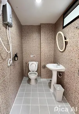 a bathroom with a toilet and a sink at Ananda Place in Ban Pa Khlok