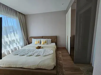 a bedroom with a bed with a teddy bear on it at The City Condo Near Central Fest Phuket, Pool view in Ban Sam Kong