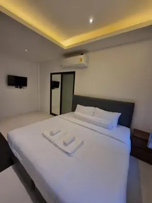 a large white bed with two white towels on it at Nua Tone Riverside Resort in Ban Thalat Choeng Thale