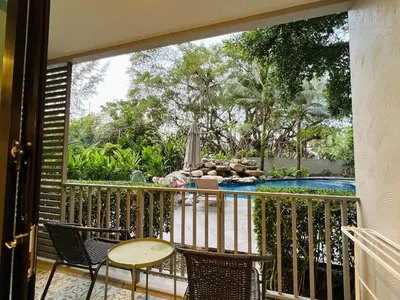 a balcony with a table and chairs and a swimming pool at The Title NaiyangPhuket1 in Phuket
