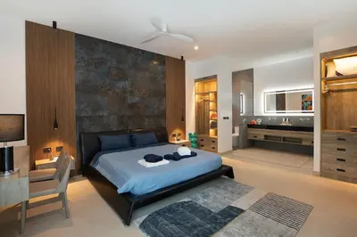 a bedroom with a bed and a desk and a bathroom at villa Lahaina in Rawai Beach