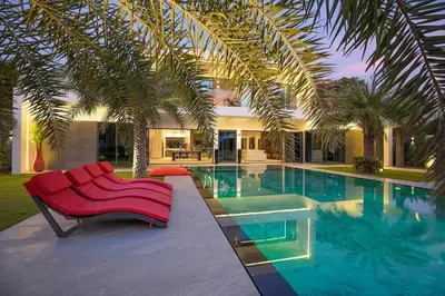 a red couch sitting next to a swimming pool at villa Lahaina in Rawai Beach