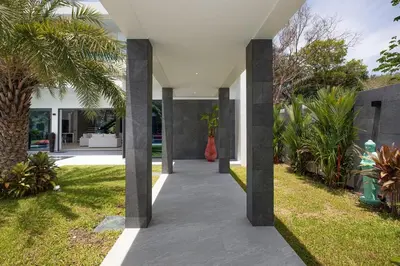 an open courtyard with palm trees and a house at villa Lahaina in Rawai Beach