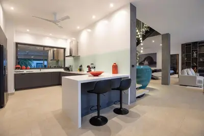 a kitchen with a counter and a bar stool at villa Lahaina in Rawai Beach