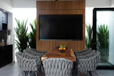 a dining room with a table with chairs and a television at Stunning 4 bedrooms pool villa at Rawai kokmakham 2 in Rawai Beach