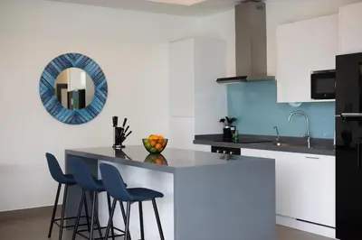 a kitchen with white cabinets and blue accents at Two-Bedroom Villa with Salt Pool in Rawai villa hapai in Rawai Beach