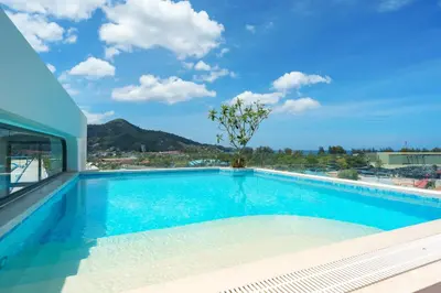 a swimming pool with a view of a building at Stylish 1 bdr Kamala beach Roof Pool Gym free wifi in Kathu