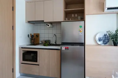 a kitchen with a stainless steel refrigerator and cabinets at Stylish 1 bdr Kamala beach Roof Pool Gym free wifi in Kathu