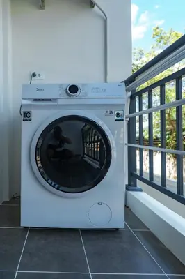 a washing machine is sitting on a balcony at Stylish 1 bdr Kamala beach Roof Pool Gym free wifi in Kathu