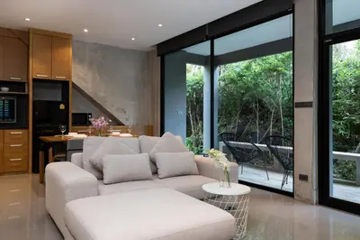 a living room with a white couch and a kitchen at 1BR Pavilion Natural Park P07 Kamala Beach in Kamala Beach