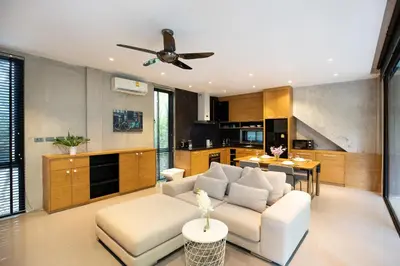 a living room with a white couch and a ceiling fan at 1BR Pavilion Natural Park P07 Kamala Beach in Kamala Beach