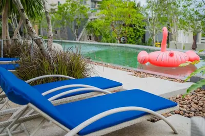 a couple of blue chairs next to a swimming pool at 1BR Pavilion Natural Park P07 Kamala Beach in Kamala Beach