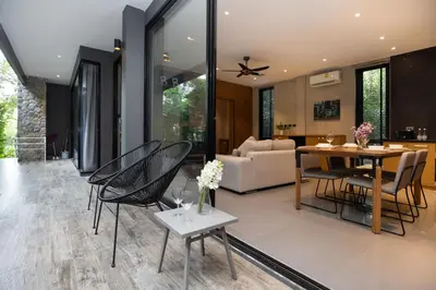 a dining room and living room with a table and chairs at 1BR Pavilion Natural Park P07 Kamala Beach in Kamala Beach