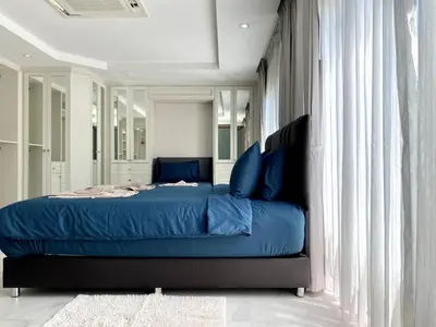 a bedroom with a bed with blue sheets and curtains at Seaview Duplex Home - Panwa Beach - Baan Jayden in Phuket Town