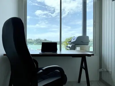 a desk with a laptop and a chair in front of a window at Seaview Duplex Home - Panwa Beach - Baan Jayden in Phuket Town