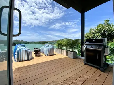 a deck with a grill and a view of the water at Seaview Duplex Home - Panwa Beach - Baan Jayden in Phuket Town