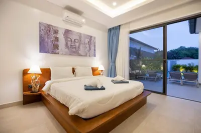 a bedroom with a large bed and a large window at Villa Malaki, pool villa 2 bedrooms at rawai in Rawai Beach