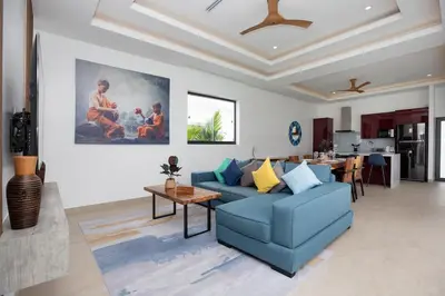 a living room with a blue couch and a table at Villa Malaki, pool villa 2 bedrooms at rawai in Rawai Beach