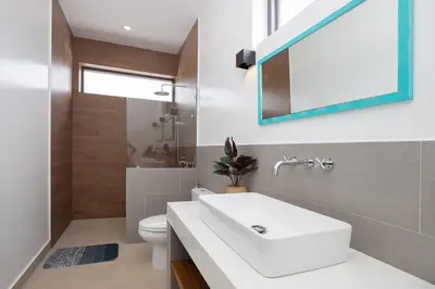 a bathroom with a sink and a toilet and a mirror at Villa Malaki, pool villa 2 bedrooms at rawai in Rawai Beach
