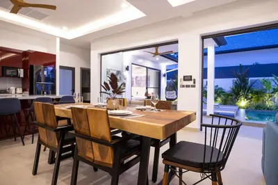 a dining room with a wooden table and chairs at Villa Malaki, pool villa 2 bedrooms at rawai in Rawai Beach