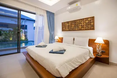 a bedroom with a large bed with two pillows on it at Villa Malaki, pool villa 2 bedrooms at rawai in Rawai Beach