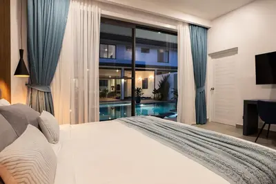 a bedroom with a large bed and a swimming pool at Sumptuous 4 bedroom pool villa at rawai beach RB 2 in Rawai Beach