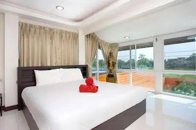 a red teddy bear sitting on a bed in a bedroom at Family Holiday 3BR Pool Villa Lancelot 2 in Rawai Beach