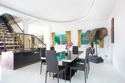 a dining room with a glass table and chairs at Family Holiday 3BR Pool Villa Lancelot 2 in Rawai Beach
