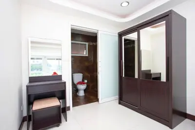 a bathroom with a toilet and a wooden door at Family Holiday 3BR Pool Villa Lancelot 2 in Rawai Beach