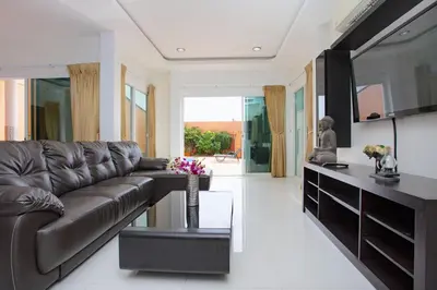 a living room with a leather couch and a table at Family Holiday 3BR Pool Villa Lancelot 2 in Rawai Beach