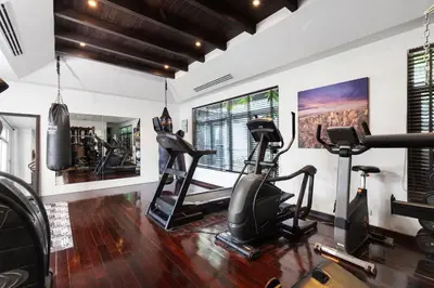 a gym with treadmills and ellipticals in a room at Spectacular Ocean Views 8BR Pool Villa Sawan in Patong! Relax & Play - Billiard, Table football, Gym & Sauna! in Patong Beach