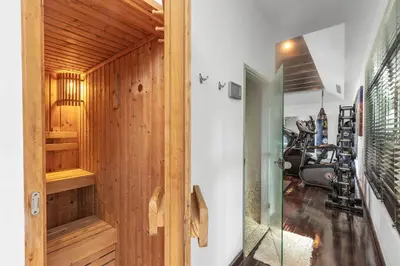 a gym with wood paneling and a glass door at Spectacular Ocean Views 8BR Pool Villa Sawan in Patong! Relax & Play - Billiard, Table football, Gym & Sauna! in Patong Beach