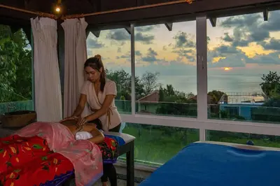 a woman holding a baby in front of a window at Spectacular Ocean Views 8BR Pool Villa Sawan in Patong! Relax & Play - Billiard, Table football, Gym & Sauna! in Patong Beach