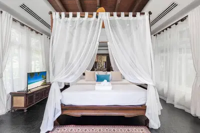 a bedroom with a canopy bed with white curtains at Spectacular Ocean Views 8BR Pool Villa Sawan in Patong! Relax & Play - Billiard, Table football, Gym & Sauna! in Patong Beach