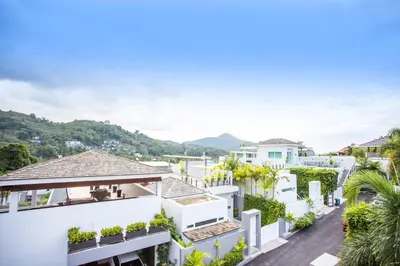 an aerial view of a white house with mountains in the background at Private 4BR Pool Villa Skylight with Stunning Views of Kamala Green Hills in Kamala Beach