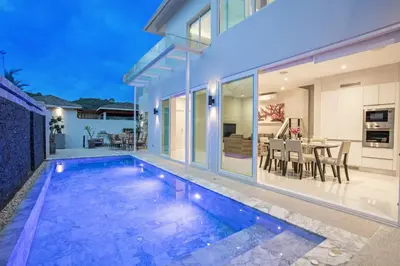 a home with a swimming pool in front of a house at Private 4BR Pool Villa Skylight with Stunning Views of Kamala Green Hills in Kamala Beach