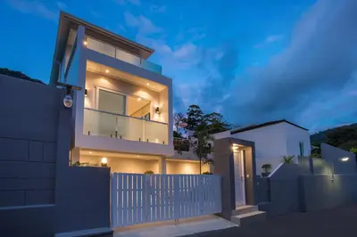 a house with a white fence in front of it at Private 4BR Pool Villa Skylight with Stunning Views of Kamala Green Hills in Kamala Beach