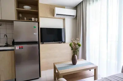 a kitchen with a refrigerator and a table with a vase at Dream 1 BdR Kamala Beach Free Parking WiFi Gym in Kathu