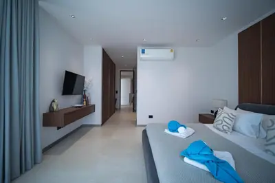 a bedroom with a bed with blue towels on it at Grand View Residence Villa by NLA in Bang Tao Beach