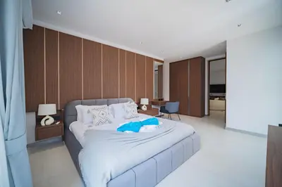 a bedroom with a bed with a blue robe on it at Grand View Residence Villa by NLA in Bang Tao Beach