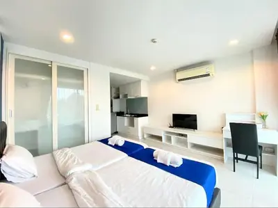 a bedroom with a large bed and a desk with a chair at The Pixel Cap Panwa Sea front Condominium - By Lovly in Ban Ao Makham