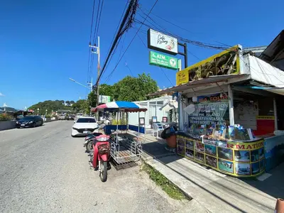 a red scooter parked in front of a food stand at The Pixel Cap Panwa Sea front Condominium - By Lovly in Ban Ao Makham