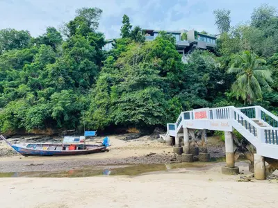 a boat on the beach with a bridge and a house at The Pixel Cap Panwa Sea front Condominium - By Lovly in Ban Ao Makham