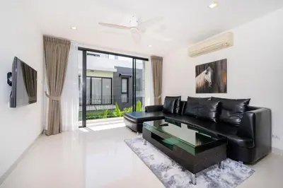 a living room with a black leather couch and a table at Phuket villa in Laguna in Bang Tao Beach